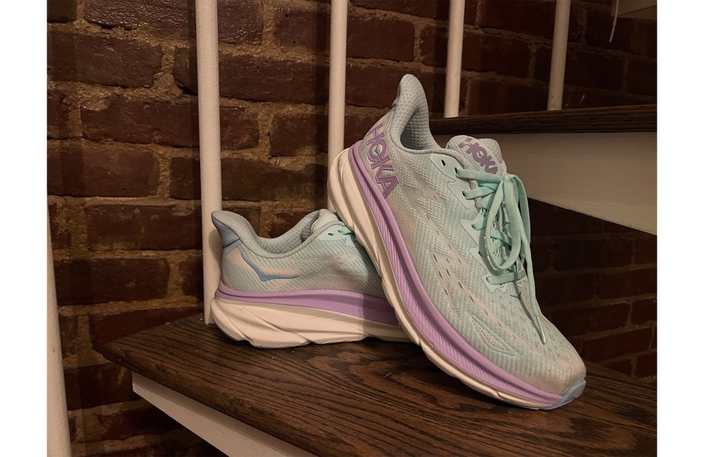 A pair of Hoka running shoes on stairs. 