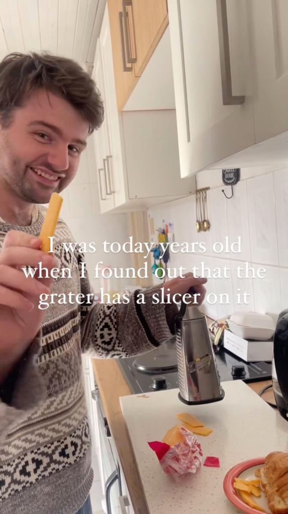 A man demonstrating how to use the lesser known side of a cheese grater to slice cheese perfectly