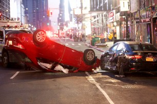 Another shot of an overturned red vehicle that had crashed into a parked car on West 40th Street and Eighth Avenue.