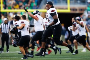 Northern Illinois' Abiathar Curry and his teammates celebrate after their upset 16-14 win over Notre Dame.