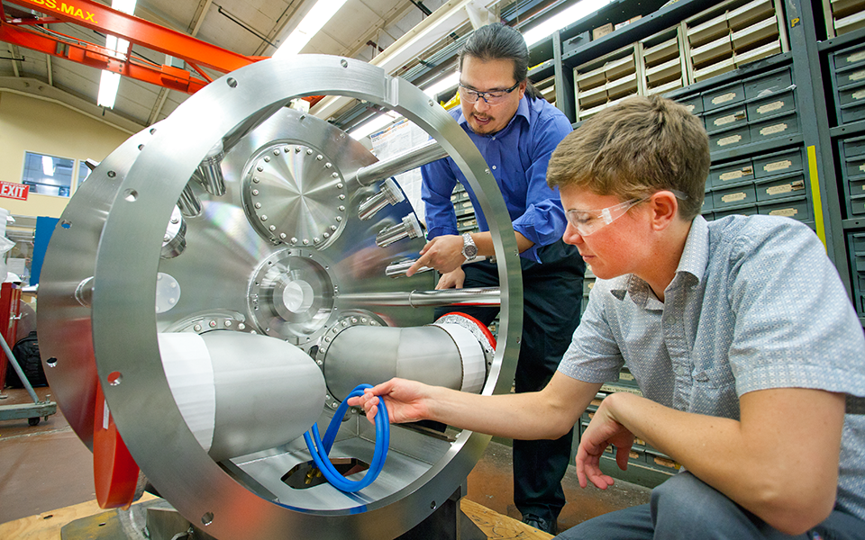 Engineer and intern inspecting blue tubing