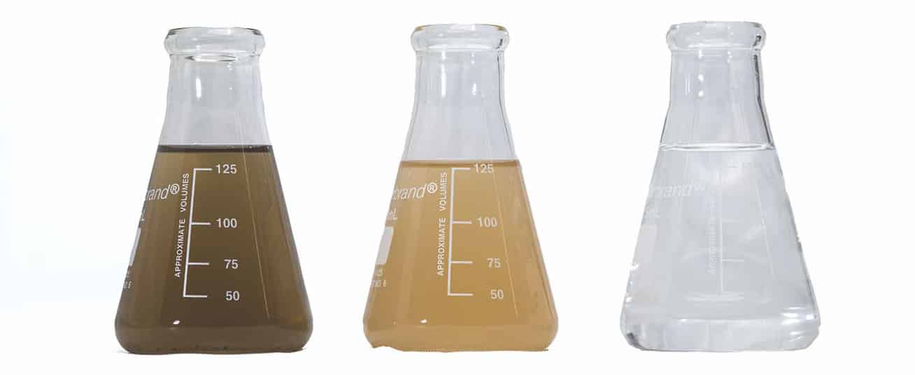 three laboratory flasks filled with liquid