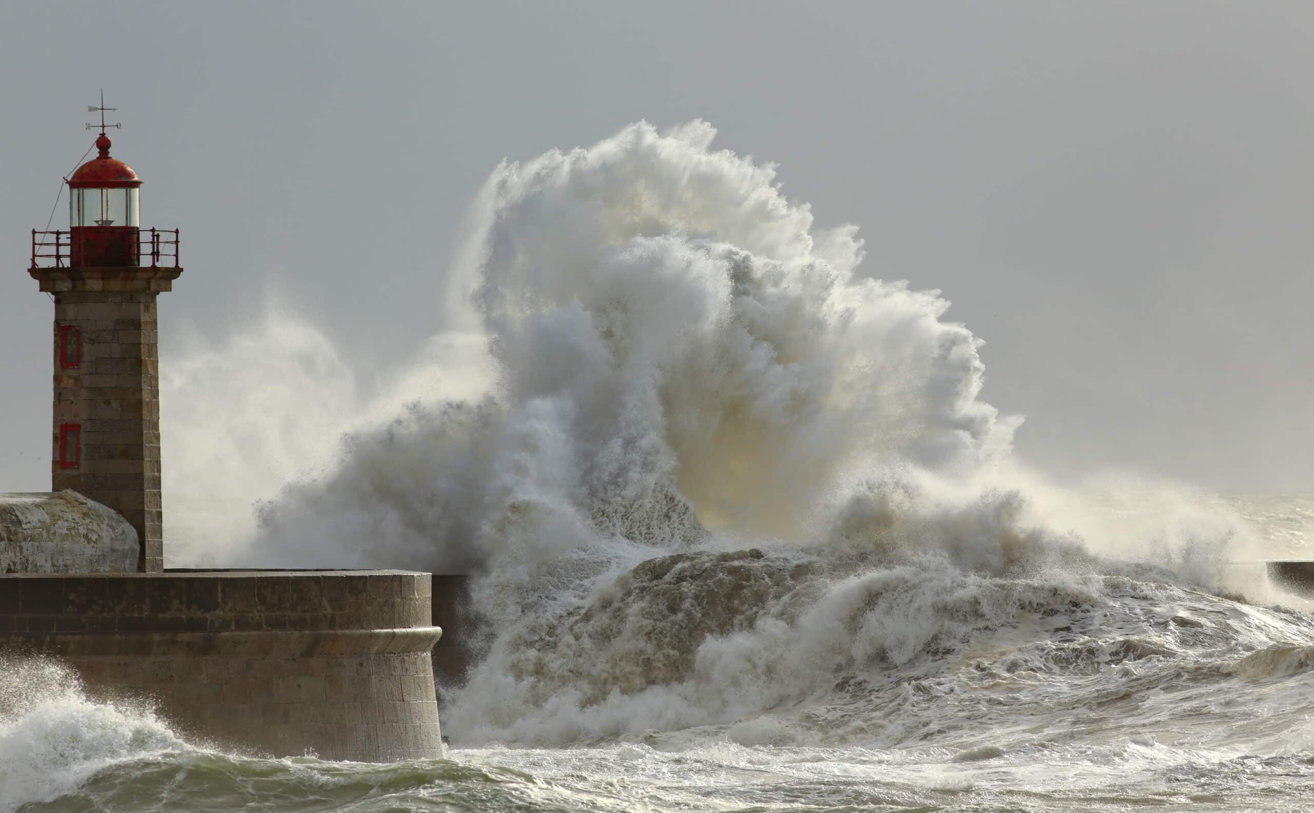 Waves crash against a coastal lighthouse