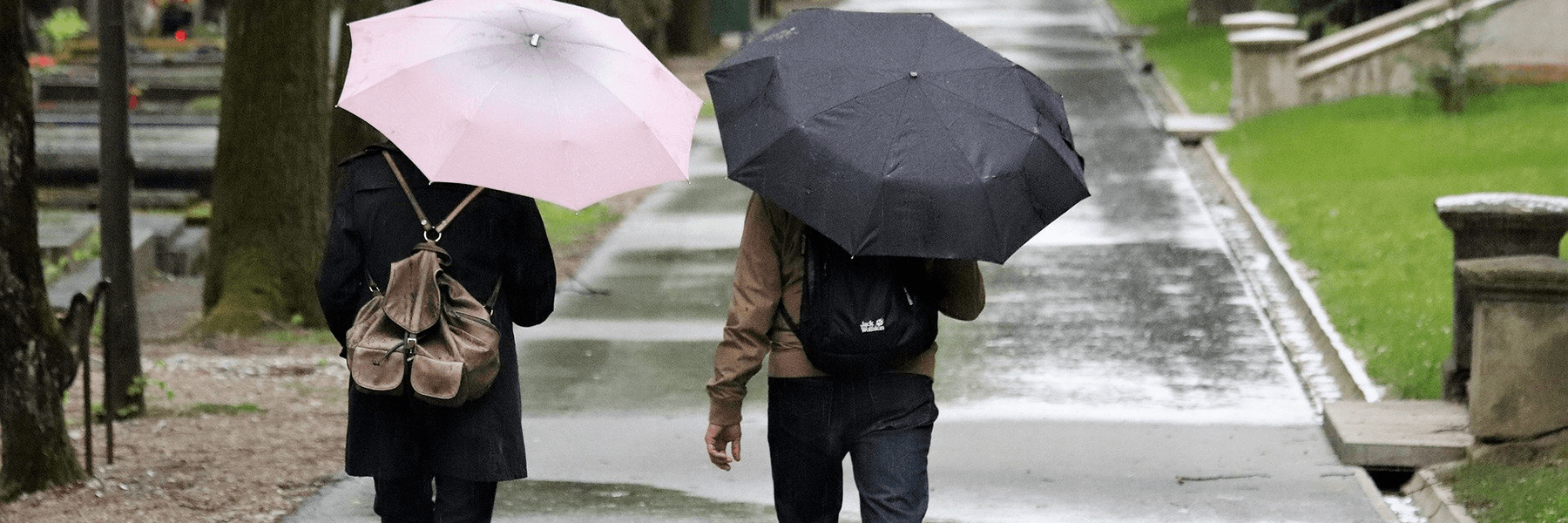 Two people with umbrellas walking in the rain.