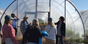 People standing in front of a greenhouse