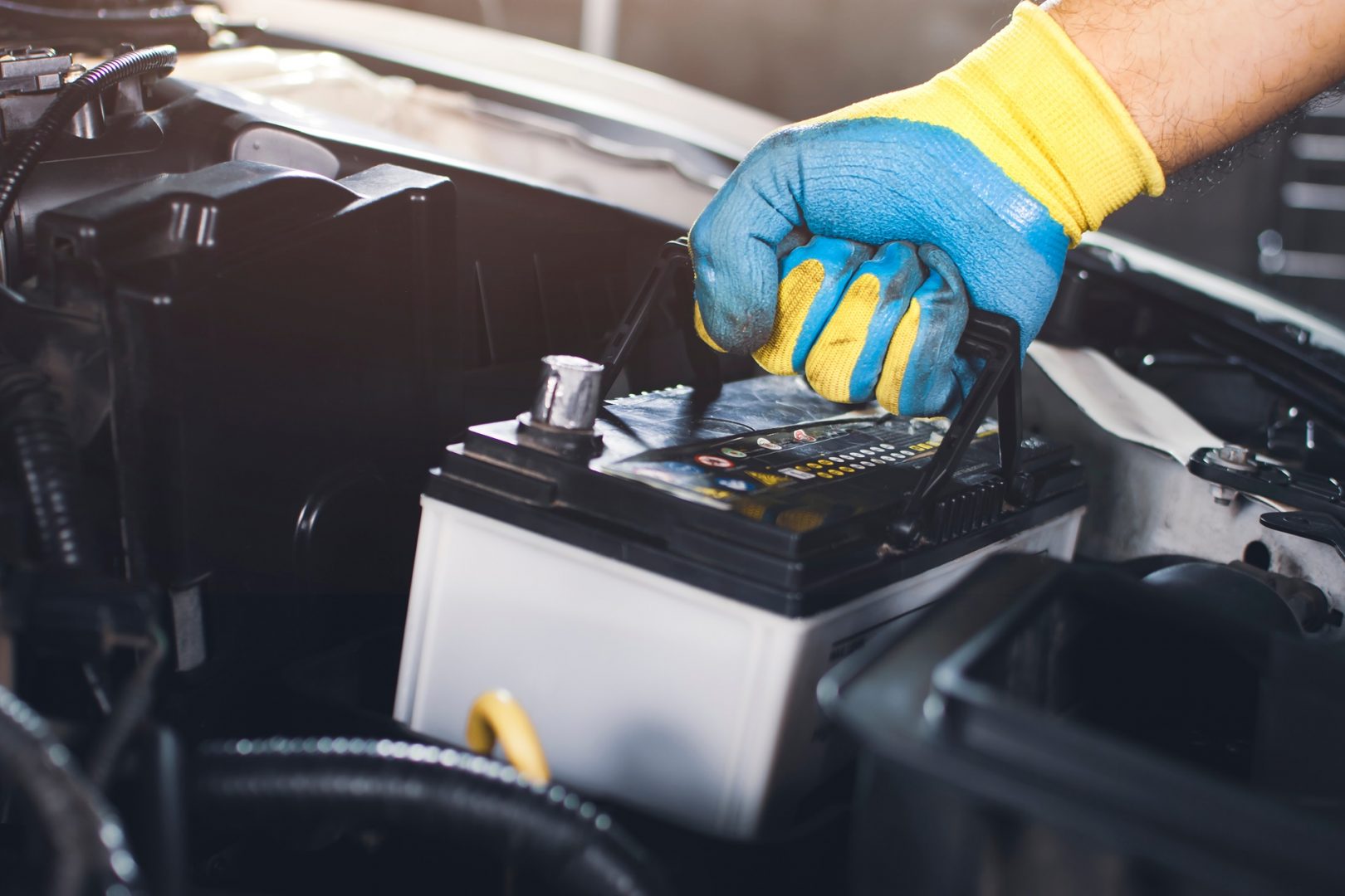 Technician,Is,Pulling,Up,An,Car,Old,Battery,For,Replacement