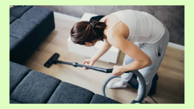 A woman cleans a hardwood floor with a vacuum