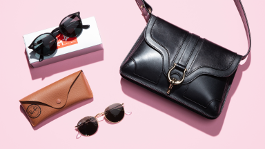 black handbag and pairs of sunglasses on pink background