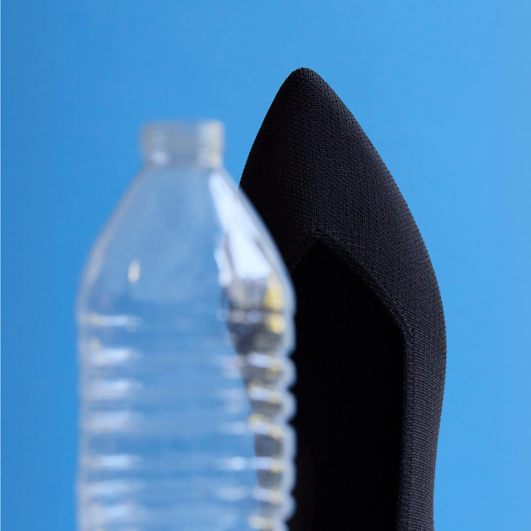 Image depicting plastic water bottle and The Point behind it.