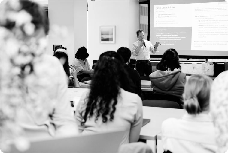 A group of people watch a presentation