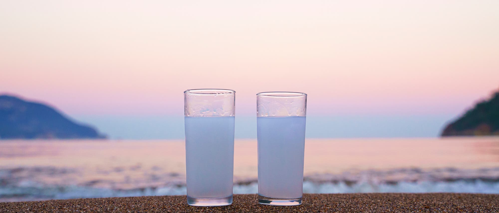 Zwei Gläser mit milchigem Ouzo am Strand