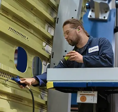 Male employee working on the outer shell of an airliner