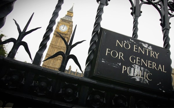 a view through the tall black gates surrounding the U.K. Parliament with a shot of Elizabeth Tower (with the Big Ben bell inside) in the distance. A sign reads, "No entry for general public."