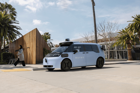 Rendering of Waymo-Zeekr robotaxi. Lilac colored minivan parked next to curb with lidar and cameras.