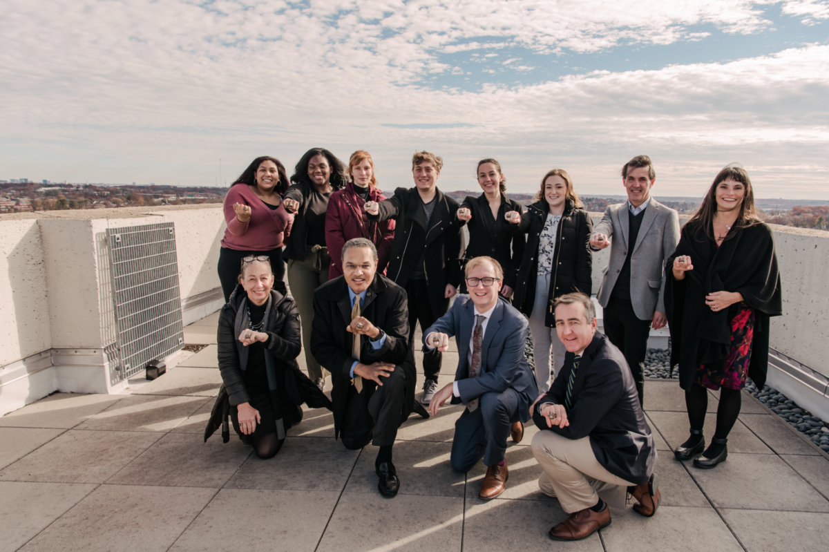 a group of students and adults posing on a roof