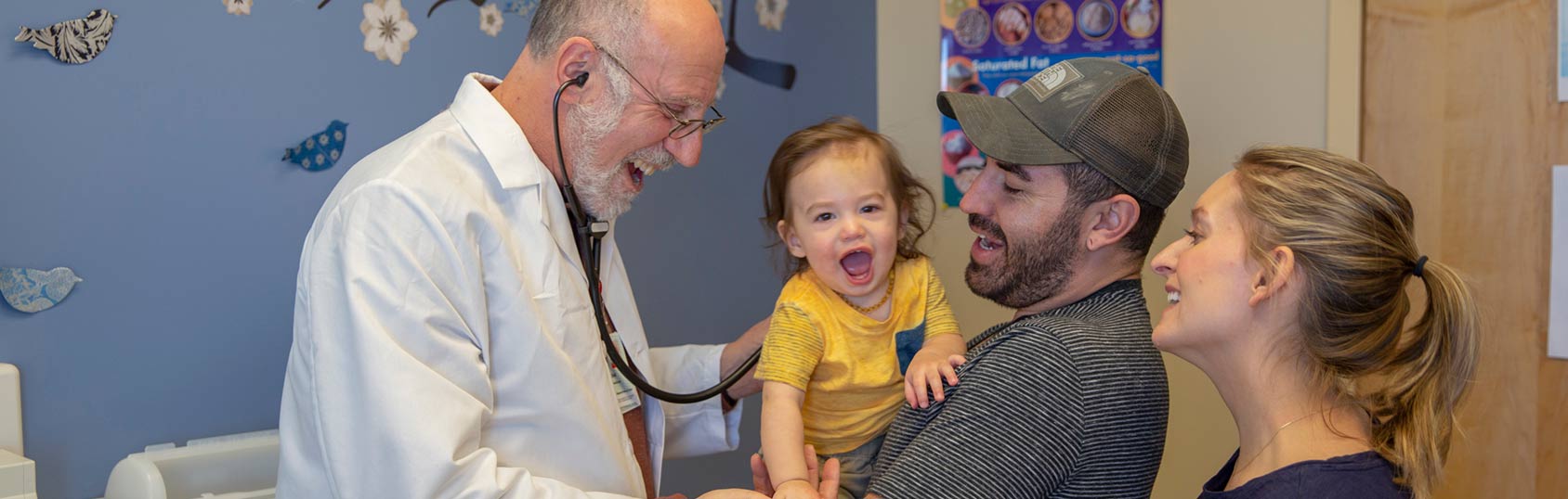 Doctor with family and child in exam room.