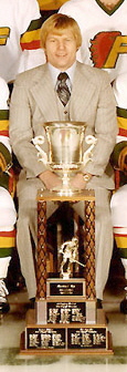 Gregg Pilling sitting behind the Lockhart Cup in a team photo of the 1976–77 Philadelphia Firebirds.