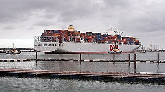 OOCL Chongqing shepherded by three tugs into Southampton