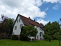 Typisch: weiße Fassade, grüne Fenster, rotes Dach