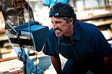 Film director Rob Bowman looking intently into a monitor.