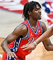 Maxey in a red basketball jersey.