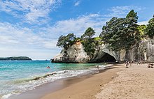 Une arche de rocher dans une falaise blanche au-dessus de la mer.