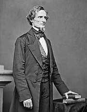 Middle-aged man in a goatee posed standing in a suit, vest and bowtie