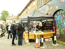 Photograph of people at a street market stall.