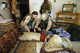 US Navy 050215-N-5319A-013 U.S Army Soldiers assigned to the 2nd Brigade Combat Team (BCT), 10th Mountain Division, render aid to a local Iraqi women who fainted as the 2nd BCT proceeds to conduct a search of her home during a.jpg