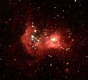 Область H II NGC 2363 при наблюдении космическим телескопом «Хаббл». NGC 2363-V1 является отдельной яркой звездой левее и выше центра[1].