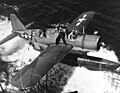 Vought OS2U-3 "Kingfisher" is recovered by USS Baltimore (CA-68) after she had rescued Lieutenant George M. Blair from Truk Lagoon, 18 February 1944. Plane's pilot is Lieutenant Denver F. Baxter. His radioman, ARMC Reuben F. Hickman, is on the wing, preparing to attach the plane so it can be hoisted on board. Blair's F6F "Hellcat", of Fighting Squadron Nine from USS Essex (CV-9), had been shot down during the dawn fighter sweep over Truk.