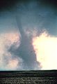 Tornado with large dust cloud obscuring funnel shape.