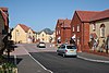 Modern suburban housing estate with cars parked.