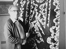 Black and white photograph of Gear in front of a painting at his Edgbaston Studio. Taken August 1979