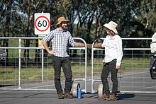 Mother and son use a V arm tube to lock on to a gate as part of a protest blockade.