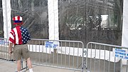 A man in a red, white and blue outfit peers into a canvas tent.