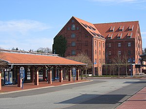 Tabakspakhuis te Bünde. Op de voorgrond het busstation.