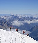 Fyra alpinister vid bergstoppen Aiguille du Midi