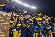 Photograph of football players exiting onto a field