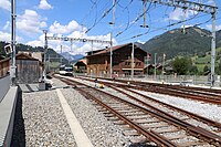 Die abgestellte MOB-Lokomotive, die den Zug nach Montreux schieben wird, wartet am Nordkopf des Bahnhofs auf dem für beide Umspuranlagen benutzten, meterspurigen Kehrgleis. Rechts unten u. rechts: Ausfädelstellen aus Vierschienengleisen.