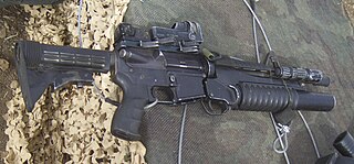 רובה M4A1 עם מטול רימונים M203 וכוונת זאבון (בצד האחורי - שמאל של הגשר) לפני כוונת ההשלכה מפרו