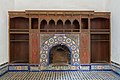 A fireplace in one of the rooms, with painted wood and zellij decoration