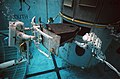 Astronauts training for repair in water tank on model of telescope