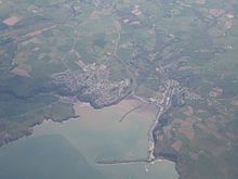 Photo à très haute altitude montrant deux agglomérations sur le pourtour d'une baie. La mer est au bas de l'image.