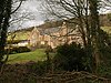 Large house seen through trees.