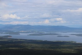 A very large lake with several islands and hills in distance