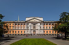 Large bâtiment orange éclairée par la lumière d'un ciel bleu