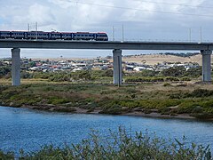 A train from the Seaford railway line travels over a viaduct spanning the Onkaparinga River.