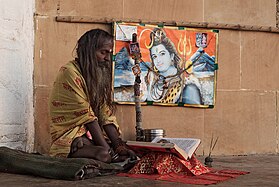 Un sādhu en posició de ioga, llegint un llibre a Benarés (Índia)