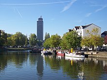 L'Erdre au premier plan, des bateaux sont à quai, les rives sont plantées d'arbres.